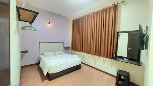 a bedroom with a bed and a large window at Hotel Bestari in Melaka