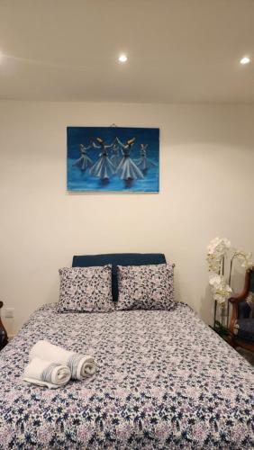 - une chambre avec un lit avec une couverture et un tableau dans l'établissement Location Studio Luxe Villejuif, à Villejuif