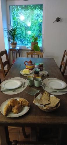 une table en bois avec des assiettes de nourriture dessus dans l'établissement MAS DU MOULIN Chambre d'hôte Vaccarès, à Arles