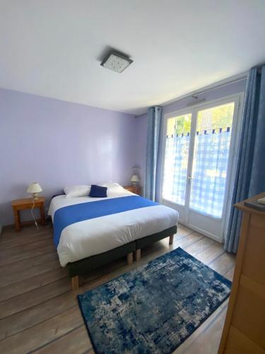 une chambre avec un lit et une grande fenêtre dans l'établissement La Cachette d'Oona, à Saint-Jean-de-Monts