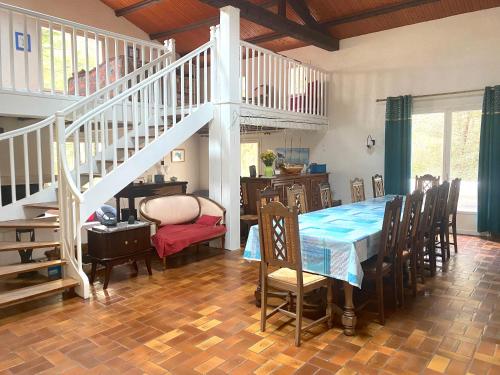 une salle à manger avec une table et un escalier dans l'établissement La Cachette d'Oona, à Saint-Jean-de-Monts