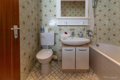 een badkamer met toilet, wastafel en bad bij Fewo Isabella in Mittenwald