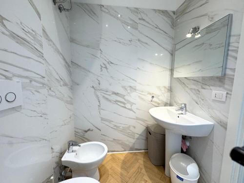 Un baño blanco con lavabo e inodoro. en Finestra sul mare, en Ospedaletti