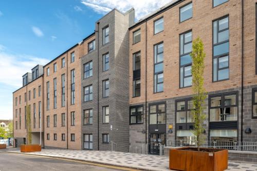 a large brick building with a tree in front of it at Student Only - Pittrodrie Street Aberdeen in Aberdeen