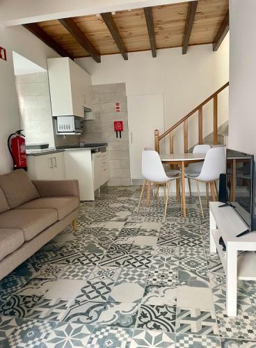 a living room with a couch and a table and chairs at Casa do Padeiro - Sintra Country Cottages II in Montelavar