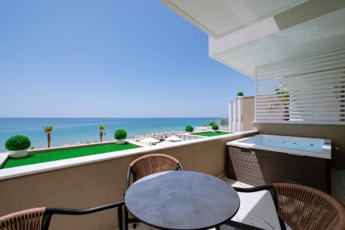 a balcony with a table and chairs and the ocean at ZEST THASSOS LUXURY RETREAT in Limenaria