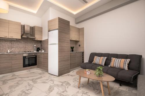 ein Wohnzimmer mit einer Couch und einem Tisch in der Unterkunft Katsaros Luxury Apts 5 min walk to beach in Planos