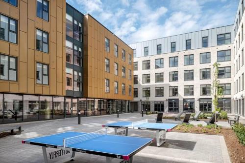 two ping pong tables in a courtyard with buildings at Student Only - Pittrodrie Street Aberdeen in Aberdeen