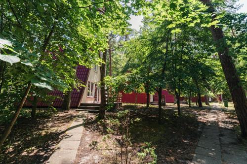 a path in front of a red building with trees at Rewita Kormoran in Hel