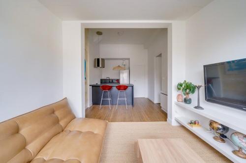 un salon avec un canapé et une télévision à écran plat dans l'établissement Charming, modern flat with private parking, à Bordeaux