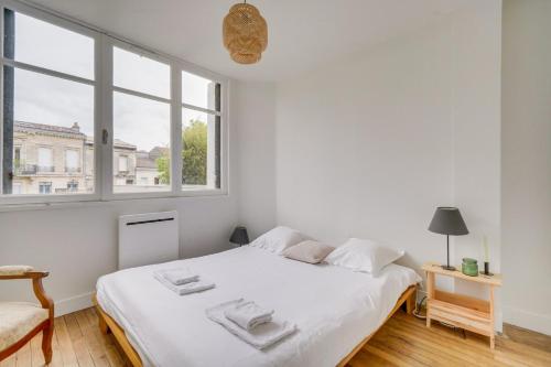 une chambre blanche avec un lit et une fenêtre dans l'établissement Charming, modern flat with private parking, à Bordeaux