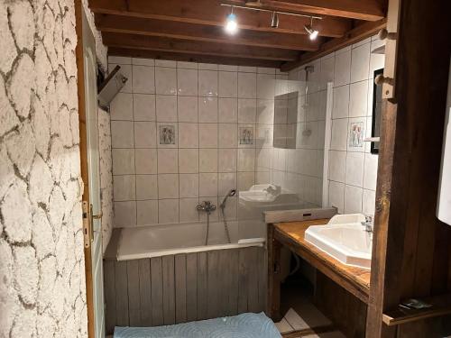 une salle de bain avec une baignoire et un lavabo dans l'établissement Le Moulin, à Sainte-Maure