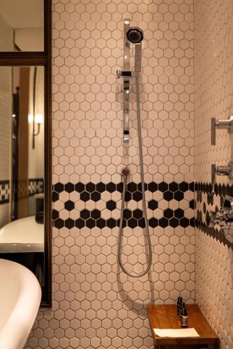 a shower in a bathroom with black and white tiles at Mumian Chengdu, in The Unbound Collection by Hyatt in Chengdu