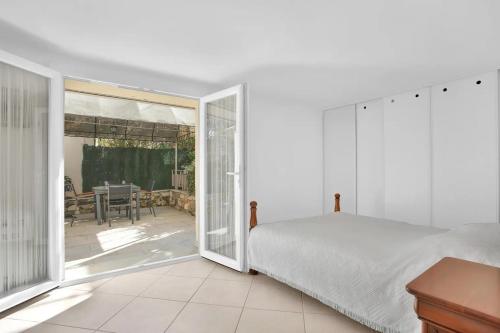 une chambre avec un lit et une porte coulissante en verre dans l'établissement Jolie 60m2 - proche des plages - 5 min centre, à Saint-Raphaël