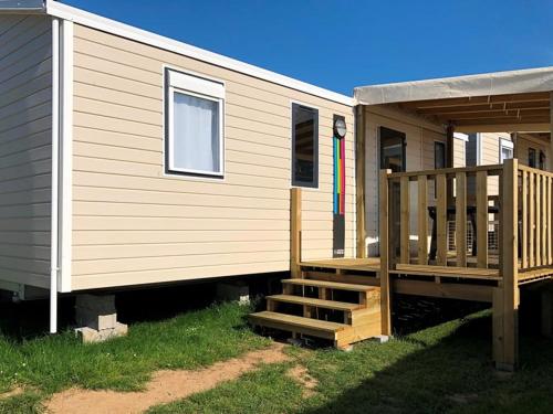un mobil-home avec un porche et une terrasse dans l'établissement Camping Paradis La Mer d'Iroise - Aquatique Vacances, à Plomodiern