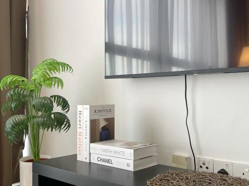 a table with two books and a plant on it at Le Petit Suite - 8 Pax Sea View Infinity Pool in George Town