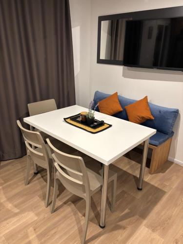 a white dining room table with chairs and a blue couch at Mobile home LUNA Selce in Selce