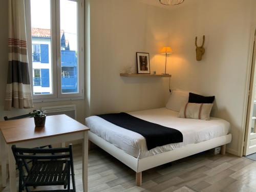 une chambre avec un lit, un bureau et une fenêtre dans l'établissement Studio cosy quartier vivant, à Biarritz