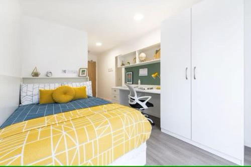 a bedroom with a yellow bed and a desk at Student Only - Pittrodrie Street Aberdeen in Aberdeen