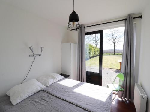 a bedroom with a bed and a large window at Holiday Home near Wadden Sea Elfsteden Route in Tzummarum