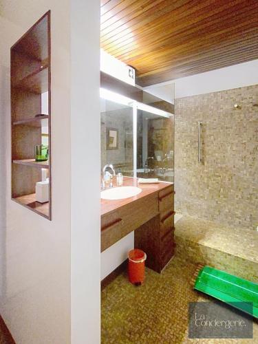 une salle de bain avec un lavabo et un miroir dans l'établissement Le Renaudot - Poitiers Centre - 70's - La Conciergerie, à Poitiers