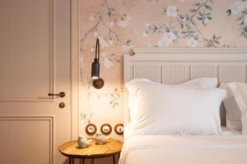 a bedroom with a white bed and a table with a side table at Robolo Boutique Hotel by H&T in Litochoro