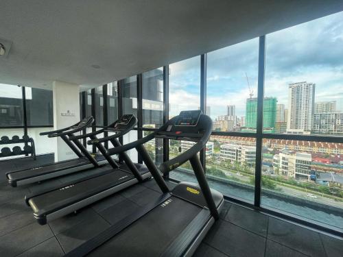 a gym with three treadmills in front of a large window at Le Petit Suite - 8 Pax Sea View Infinity Pool in George Town