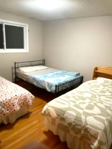 a bedroom with two beds and a window at LONG WEEKEND BUMPER OFFER- Transit,Airport,Downtown Minutes Drive in Kitchener