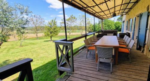 a wooden deck with a table and chairs on it at Maison Neuve, relaxing countryside home with pool in Chillac