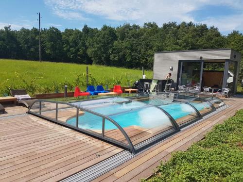 a deck with a swimming pool and a trailer at Maison Neuve, relaxing countryside home with pool in Chillac