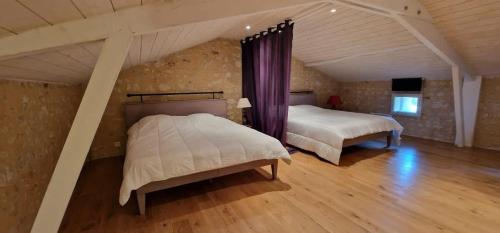 a bedroom with two beds in a attic at Maison Neuve, relaxing countryside home with pool in Chillac