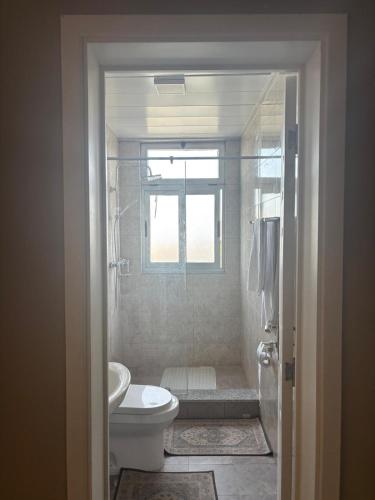un bagno con wc, doccia e finestra di Jambo apartment 2 ad Addis Abeba