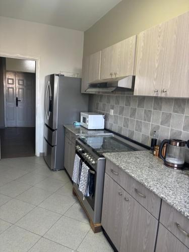 una cucina con frigorifero e fornello forno superiore di Jambo apartment 2 ad Addis Abeba
