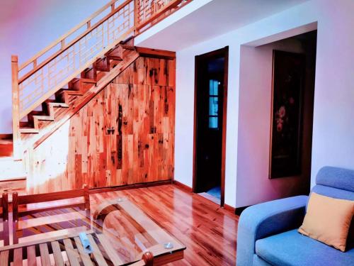 a living room with a staircase and a blue couch at 淳安千岛湖乡庐怡陌民宿 in Thousand Island Lake