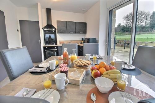 - une table à manger avec de la nourriture et des fruits dans l'établissement La grange du petit kernon, à Plouvara