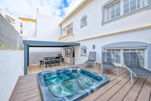 a hot tub on the deck of a house at Full private 180sqm Villa - Terrace Jacuzzi - 200m Beach & Sea View in Albufeira