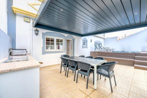 a kitchen and dining room with a table and chairs at Full private 180sqm Villa - Terrace Jacuzzi - 200m Beach & Sea View in Albufeira