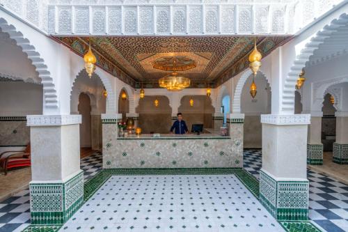 a man standing at a bar in a building at Palais Moulay Said & SPA in Marrakech
