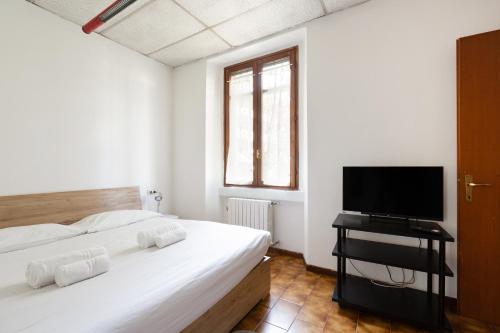 una camera da letto con due letti e una TV a schermo piatto di GuestHost - M3 Lodi Tibb-Brenta Comfy Flat a Milano