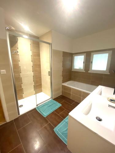 une salle de bain avec une douche, un lavabo et une baignoire dans l'établissement La Cachette d'Oona, à Saint-Jean-de-Monts