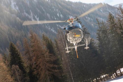 a helicopter is flying over a mountain at Montana Lodge & Spa, by R Collection Hotels in La Thuile