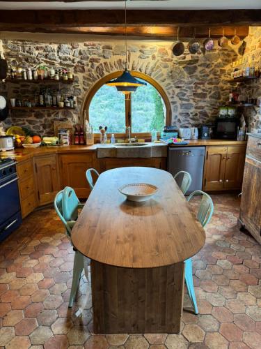 une cuisine avec une table en bois et des chaises. dans l'établissement La Boussonie, Mas de caractère au pays des Vans, aux Vans