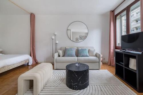 un salon avec un canapé et un miroir dans l'établissement Spacious Apt 4PAX - Paris Courbevoie, à Courbevoie