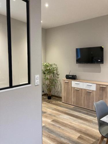 une pièce avec une télévision au mur et une chaise dans l'établissement Séquoi, à Vals-les-Bains