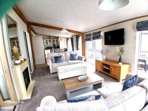a living room with two couches and a tv at Luxury Lodge at Southview - perfect for couples with pond view and sun room in Skegness