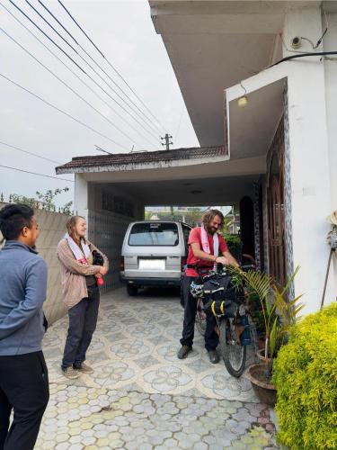 a man and a woman standing outside a house with a bike at G P Homestay in Dibrugarh
