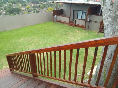 a wooden railing on a balcony with a yard at The Gregory in Pinetown