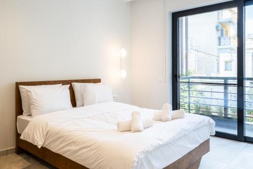 a bedroom with a large white bed with a large window at Grec Suites Dafni, Athens by GrecCollection in Athens