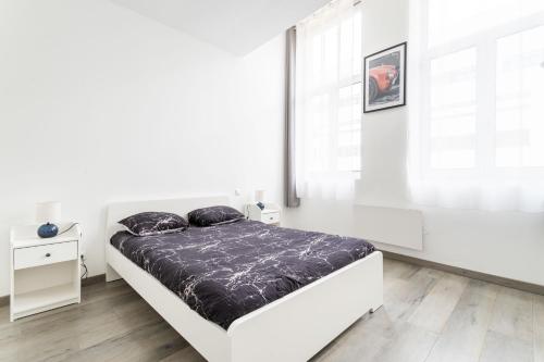 une chambre blanche avec un lit et une fenêtre dans l'établissement Le séjour Douaisien - Proche Gare & Centre, à Douai