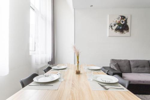 une salle à manger avec une table et un canapé dans l'établissement Le séjour Douaisien - Proche Gare & Centre, à Douai
